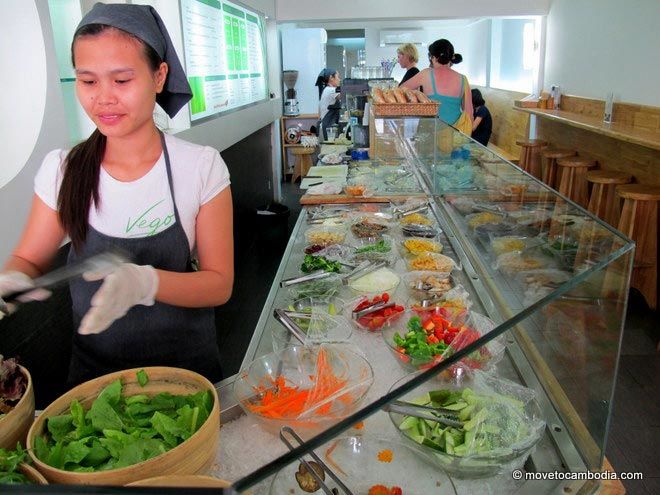 working in Cambodia A woman working at a salad bar in Cambodia.