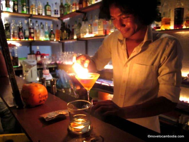 Tuk Tuk Bar Siem Reap Hong Kry makes a drink with flair in a real tuk tuk at Siem Reap's Tuk Tuk Bar.