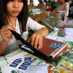 Girl cutting passport photos at Good Luck Printing Phnom Penh